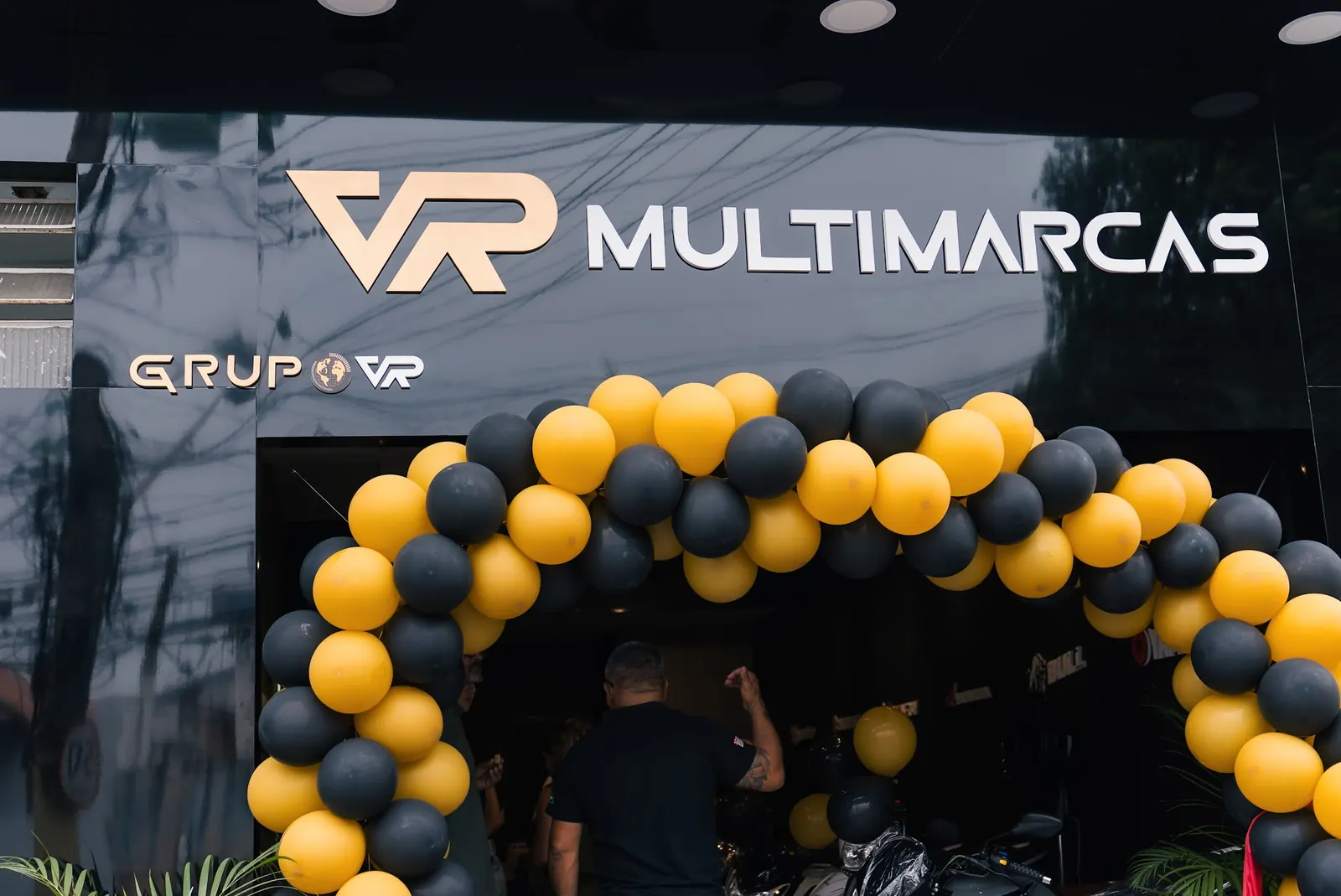 Fachada da VR Multimarcas São José dos Campos com o letreiro Grupo VR e arco de balões na inauguração