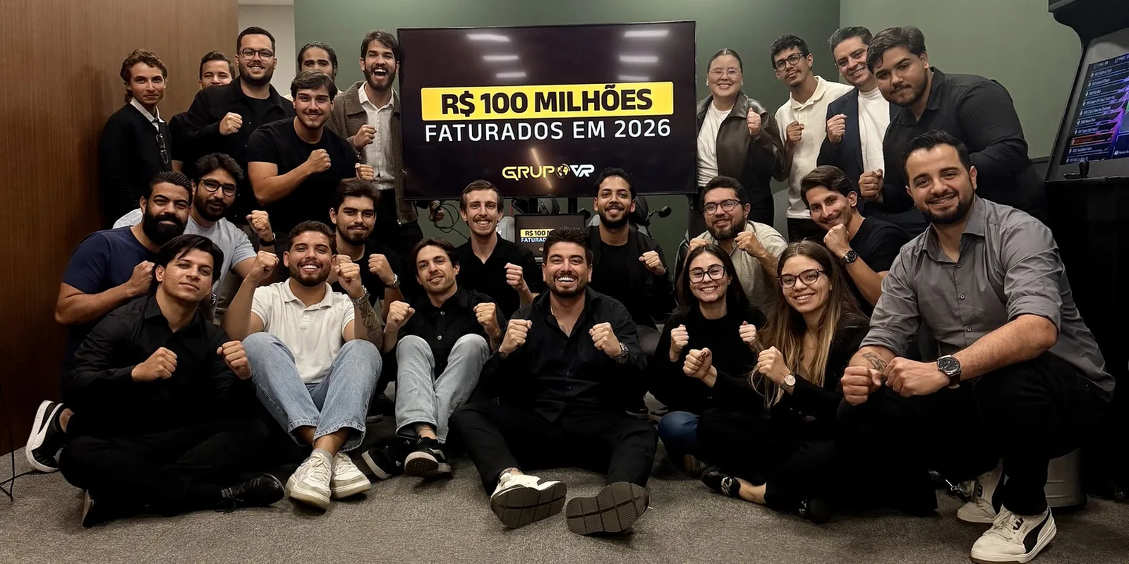 Time do Grupo VR comemorando R$ 100 milhões faturados em 2026, com Daniel Rodrigues ao centro